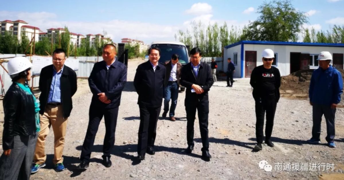 Front Commander and Ili Prefecture Party Secretary Pan Daojin (center) inspects internment factory dormitory construction with the Nantong “Xinjiang Aid” Working Group in May 2018.