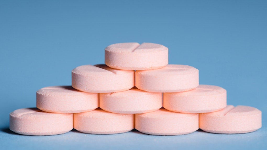 stack of pink pills blue background