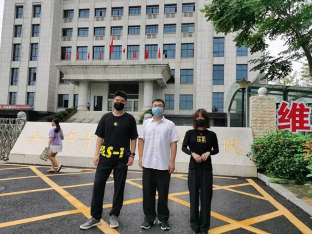 plaintiffs three former students at YuZhang Academy standing in front of the court