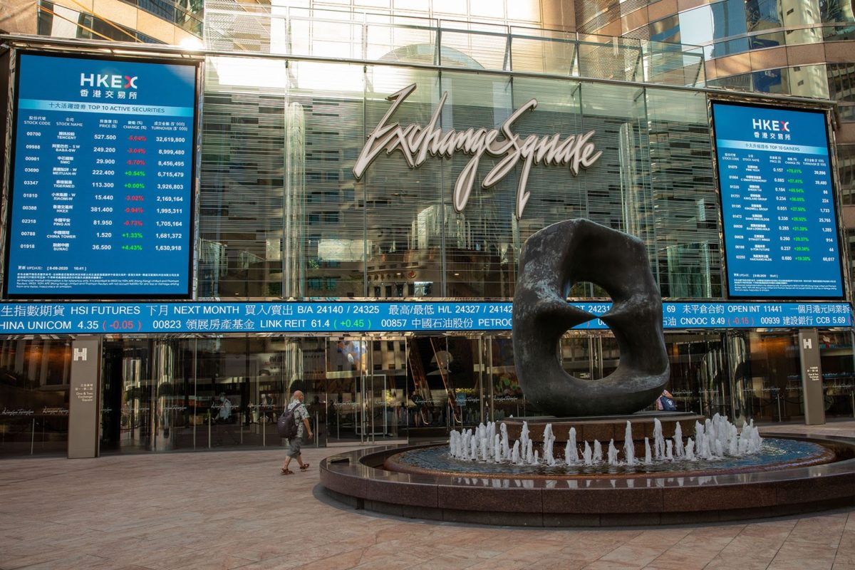 a photo of the hong kong stock exchange, with a fountain in front of electronic boards