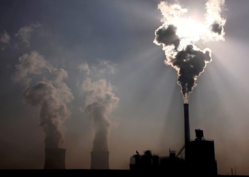 a coal power plant in baotou inner mongolia letting off steam with the sun in the background