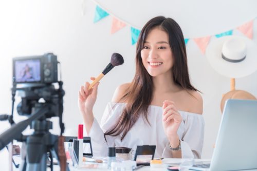 Chinese fashion blogger / vlogger films a review of makeup products for use on live-streaming marketing sites like Zhibo Daihuo