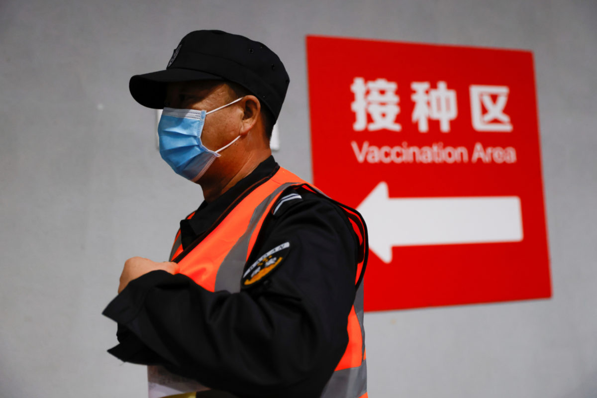 a man in china walking to receive a COVID-19 vaccine