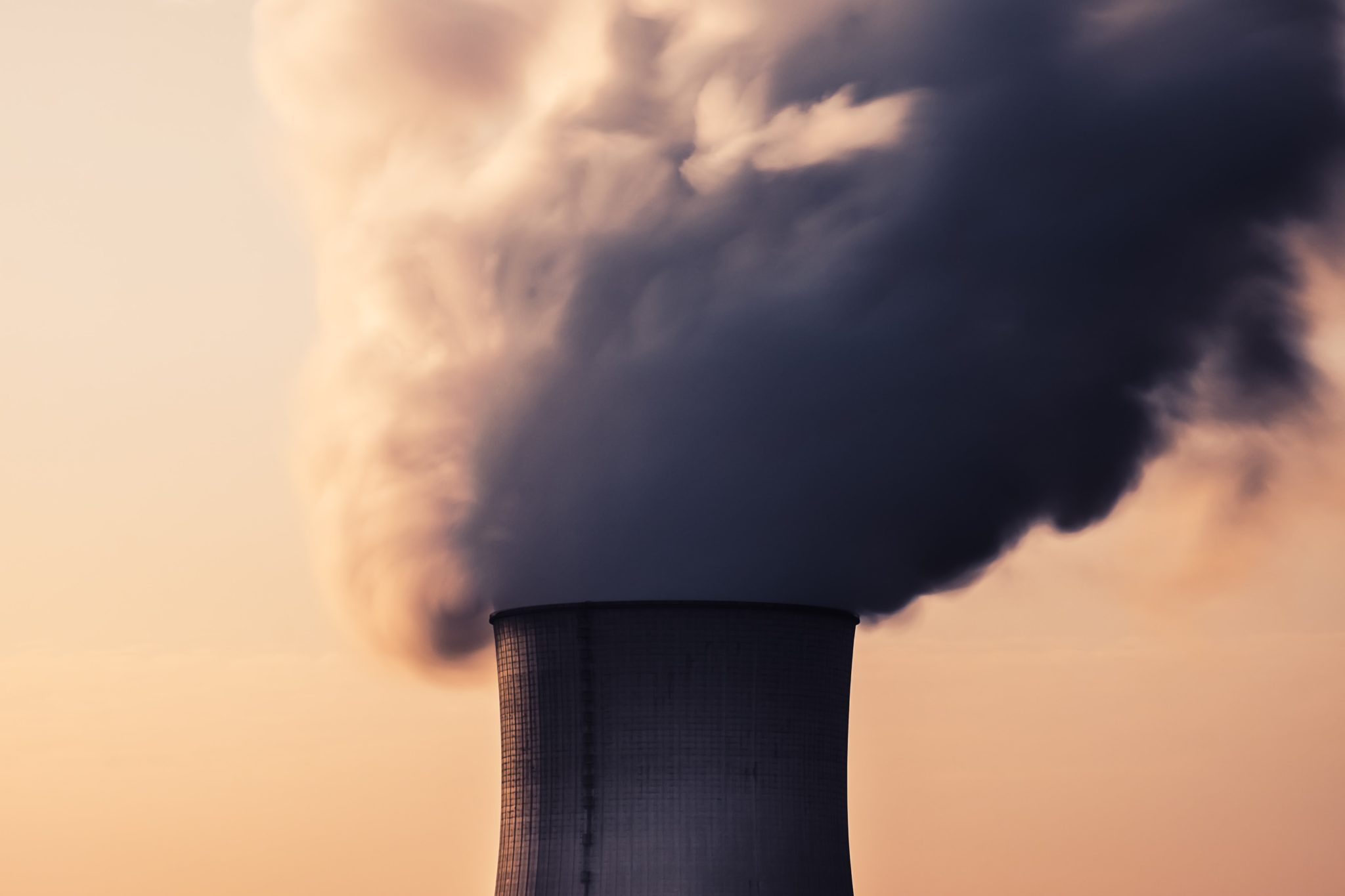 Steam billows from a nuclear power plant's cooling tower