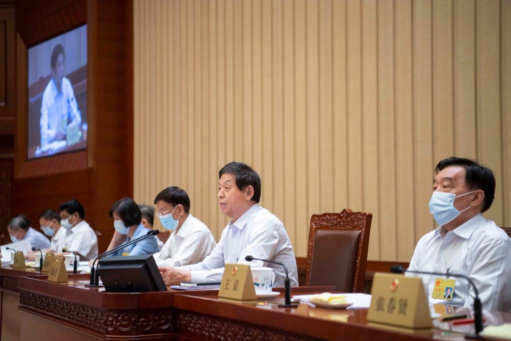 li zhanshu, a senior chinese official, conducting a meeting in beijing with several other members of the national people's congress standing committee sitting beside him